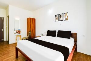 a bedroom with a large white bed in a room at Super Collection O Bannergatta Road Near Decathlon in Bengaluru