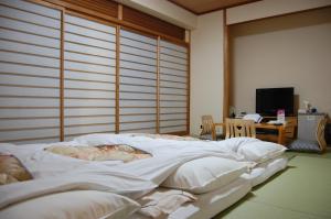 a bedroom with a large bed with white sheets at Hotel Sunroute Aomori in Aomori +48 photos