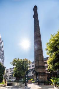 a tall monument in front of a building at Cachet Boutique Kunming Artime in Kunming