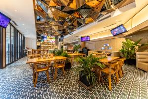 a restaurant with wooden tables and chairs and plants at Cachet Boutique Kunming Artime in Kunming