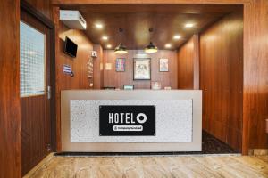 a hotel reception desk in a room with wooden walls at Hotel O Canal Road in Dehradun