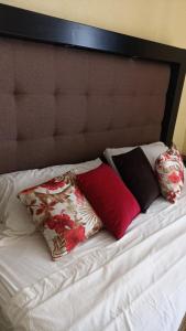 a bed with three pillows on top of it at Departamento Tapatío in Guadalajara