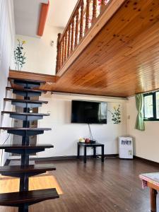 a living room with a staircase and a flat screen tv at Old Street Seaview Homestay in Jiufen