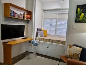 a living room with a window seat with a flat screen tv at Eco Gallery Apartment in Fremantle