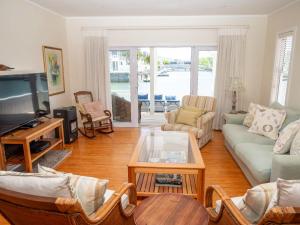 a living room with a couch and a tv at Thesen Island Villas in Knysna