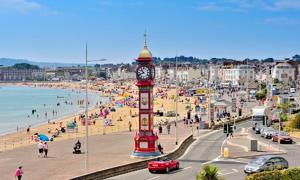 a clock tower on a beach with a crowd of people at Admiralty House in Weymouth +22 photos