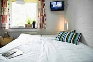 a white bed in a room with a tv on a wall at Danhostel Sønderborg City in Sønderborg