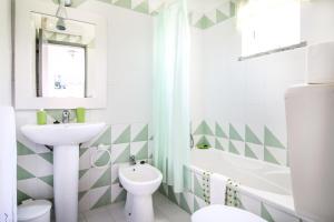 a bathroom with a sink and a toilet and a tub at Casa Morais in Odeceixe