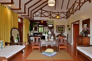a living room with a table and chairs and a kitchen at Porta Verde Resort Cavinti Laguna with Lake View in Cavinti