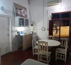 a room with a table and chairs and a kitchen at Casita B in Asunción