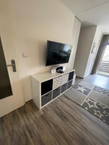 a living room with a flat screen tv on a white cabinet at Hexe III in Altenau