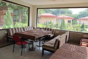 a restaurant with a table and chairs and a large window at Design Galleries Complex in Faridabad +1 photo