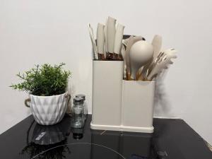 two white containers filled with utensils on a table at Olum Beach Loft in Antón Lizardo