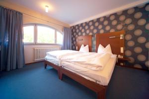 a bedroom with a bed and a large window at Landhotel zum Schwanen mit Restaurant Mona Liza in Osthofen