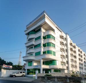 根尼亚古马里Hotel Staar World的一栋建筑前停着一辆车