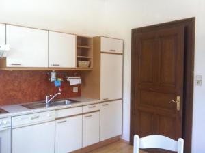 a kitchen with white cabinets and a sink and a door at Villa Martiny in Seeboden