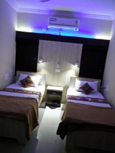 那格浦爾的住宿－Shivam Apartment，紫色灯房内的两张床