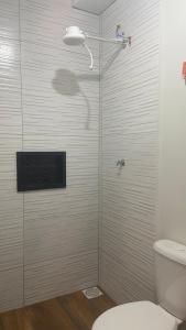 ピラカイアにあるChácara Recanto da Pazのバスルーム(シャワー、トイレ付)、テレビが備わります。