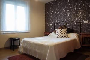 a bedroom with a bed with a black and white wall at La Casa De Luarca in Luarca