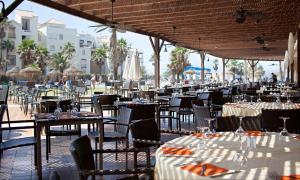 a dining area with tables and chairs and umbrellas at AR Almerimar in Almerimar