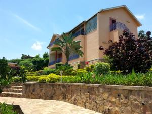 ein Gebäude mit einer Palme davor in der Unterkunft Villa Belle Vue in Kigali