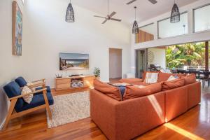 a living room with a couch and a tv at Lazuli in Blueys Beach
