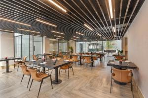 a dining room with tables and chairs and windows at ZANA by the Ganges, Tapovan, Rishikesh in Rishīkesh +30 photos