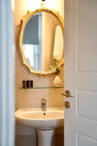 a bathroom with a sink and a mirror at Apiro Syros in Ermoupoli +29 photos
