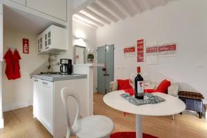 una pequeña cocina y una mesa con una botella de vino en Mamo Florence - Dado Suite, en Florencia