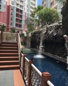 une cascade dans une piscine d'un complexe hôtelier dans l'établissement Grande Caribbean Condo Resort one-bedroom near Walking street and Jomtien Beach, à Pattaya (sud)