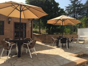 two tables and chairs with umbrellas on a patio at B&B Casa Dolce Luna in Cosenza