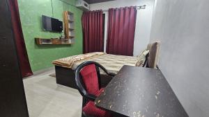 een kleine kamer met een tafel en een stoel en een kamer met een tv bij Sukdham Homestays Mathura! in Mathura