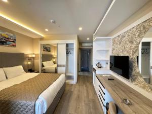 a bedroom with a bed and a flat screen tv at Parla Park Otel in Yazır