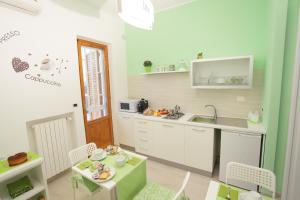 eine Küche mit einem Waschbecken und einem Tisch mit Stühlen in der Unterkunft B&B San Domenico in Modugno