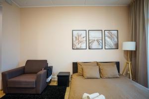 a living room with a bed and a chair at Cozy city center studioapartment, Free parking in Pärnu