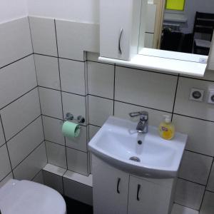 a bathroom with a sink and a toilet and a mirror at Apartment Ekaterininskaya 5 in Simferopol