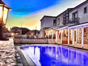 a house with a swimming pool in front of a building at Alacati Alaris Hotel in Alaçatı