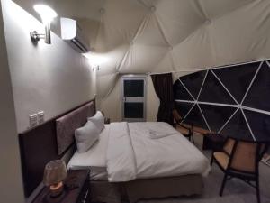 a bedroom with a tent with a bed and a table at Wildlife Camp in Disah +19 photos