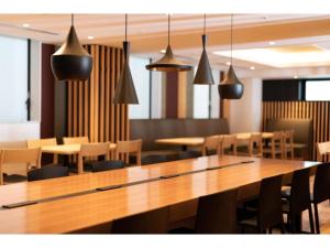 a dining room with a large wooden table and chairs at The OneFive Kyoto Shijo - Vacation STAY 41806v in Kyoto