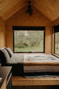 1 dormitorio con ventana grande en una casa pequeña en Secluded & Pet Friendly Cabin Deep in Nature - Cybele, en Coleyville
