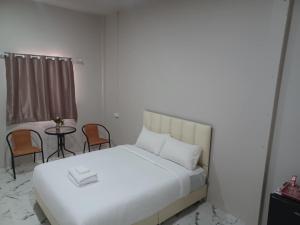 a bedroom with a bed and a table and chairs at MWELL House in Ban Klang