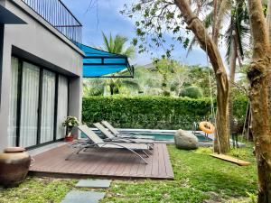 a patio with lounge chairs next to a swimming pool at Maribel Villa Phu Quoc in Phu Quoc