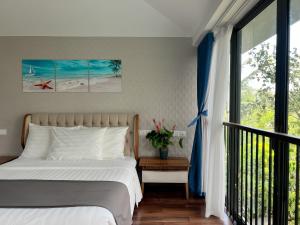 a bedroom with a bed and a large window at Maribel Villa Phu Quoc in Phu Quoc +49 photos