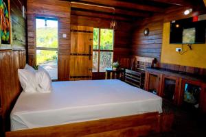 a bedroom with a white bed in a wooden room at Sailors cabin in Nuwara Eliya