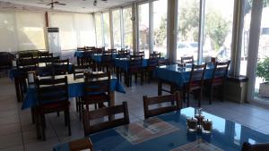 a restaurant with blue tables and chairs and windows at Camlikosk Apart Hotel in Bodrum City