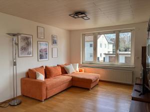 a living room with a couch and a large window at Ferienwohnung im Heiligenberg in Langenburg