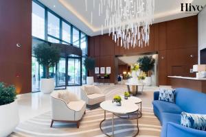 a lobby with a blue couch and chairs and a chandelier at Luxury 2 Bed in Address Opera Residences in Dubai