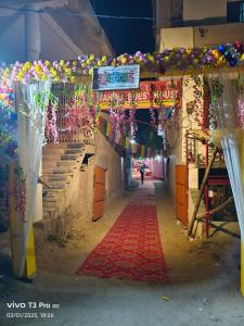 un vicolo con un tappeto rosso e dei fiori sopra di Mahima Guest House a Bodh Gaya