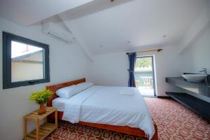 a white bedroom with a bed and a sink at Hoian Beachfront Homestay in Tân Thành (1)