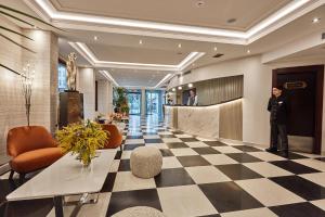 mężczyzna w garniturze stojący w holu w obiekcie Konak Hotel Taksim w Stambule